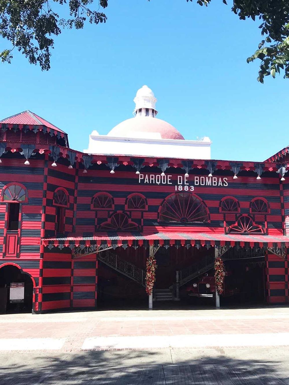 Colorful historic fire station at Parque de Bombas, iconic landmark in Ponce, Puerto Rico, with vibrant red and black stripes.