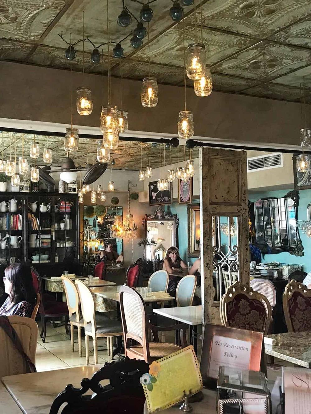 Elegant vintage-style restaurant interior with warm lighting and eclectic decor, perfect for dining and socializing.