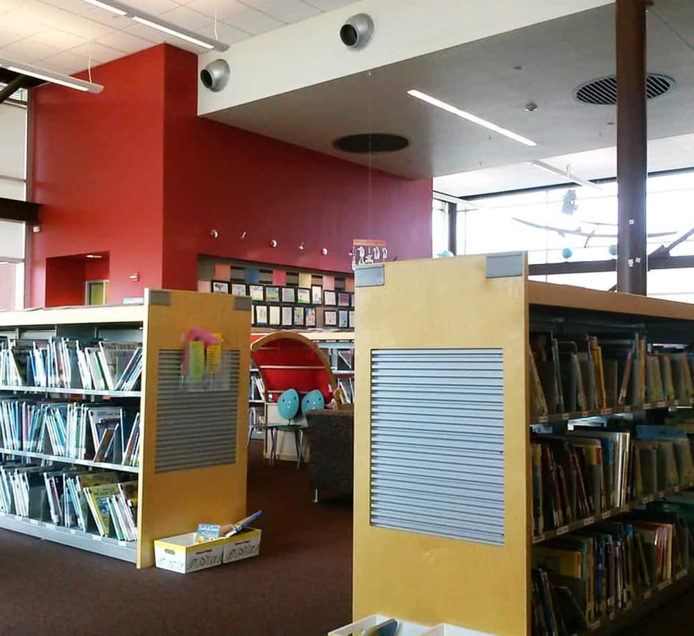 Bright library with colorful bookshelves, reading area, and natural light, ideal for students seeking educational resources.