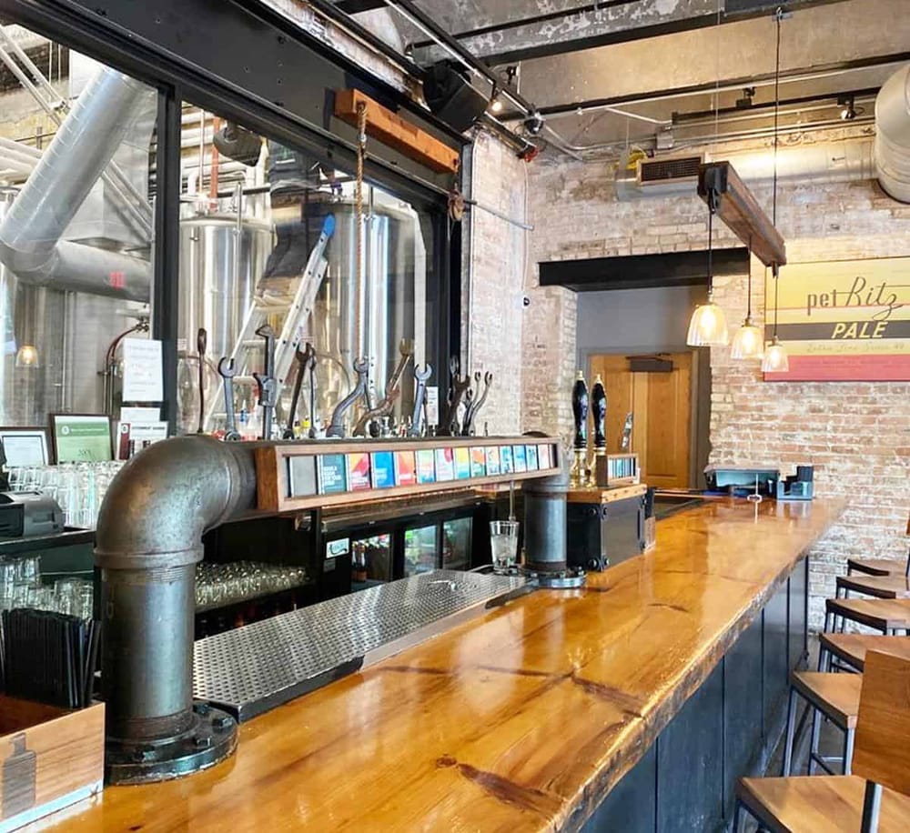 Craft brewery bar with taps, rustic brick walls, and industrial decor at QuestForDirections.