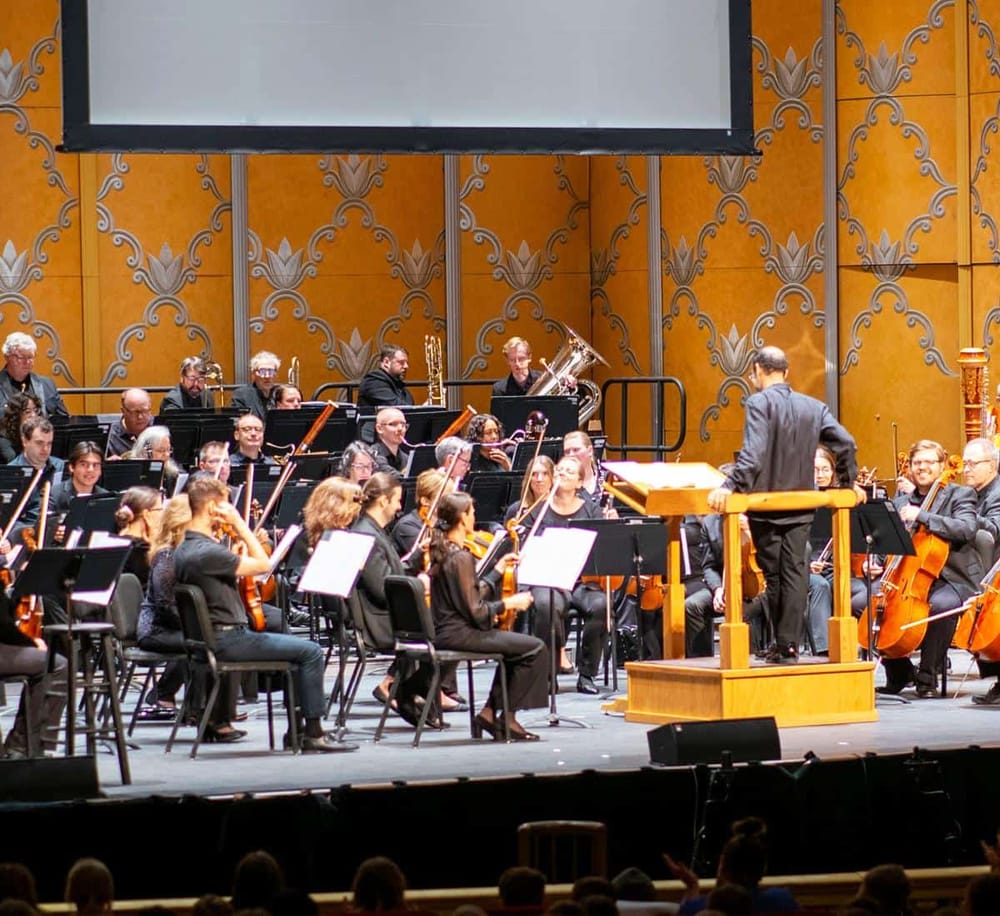 Orchestra performing live on stage at a concert hall, captured during a classical music performance.