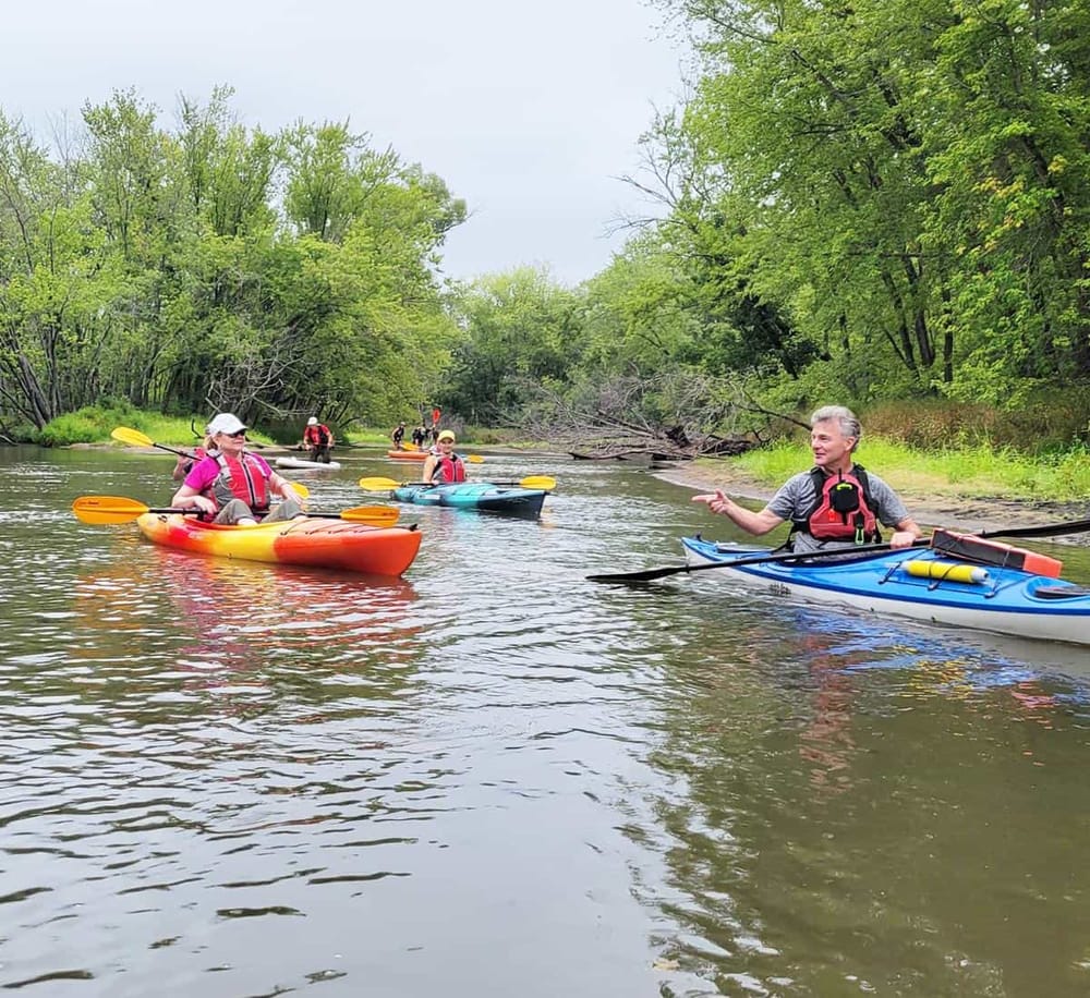 1. Kayaking on a scenic river with lush green trees and calm waters, outdoor adventure.