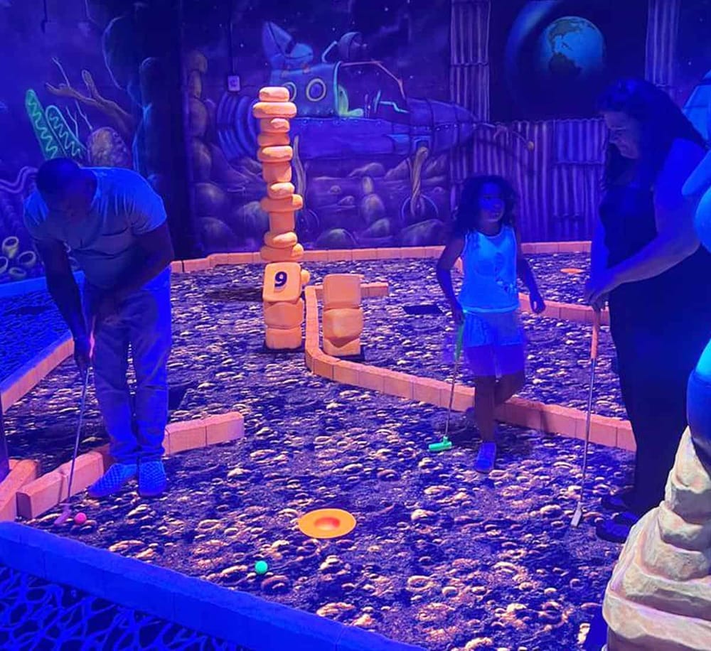 Colorful mini golf game for kids under blacklight at QuestForDirections. Family fun and entertainment for all ages.