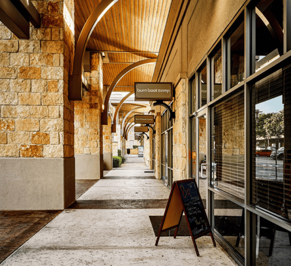 1. Attractive shopping center with stone and wood architectural details, inviting storefronts, and clear directional signage.