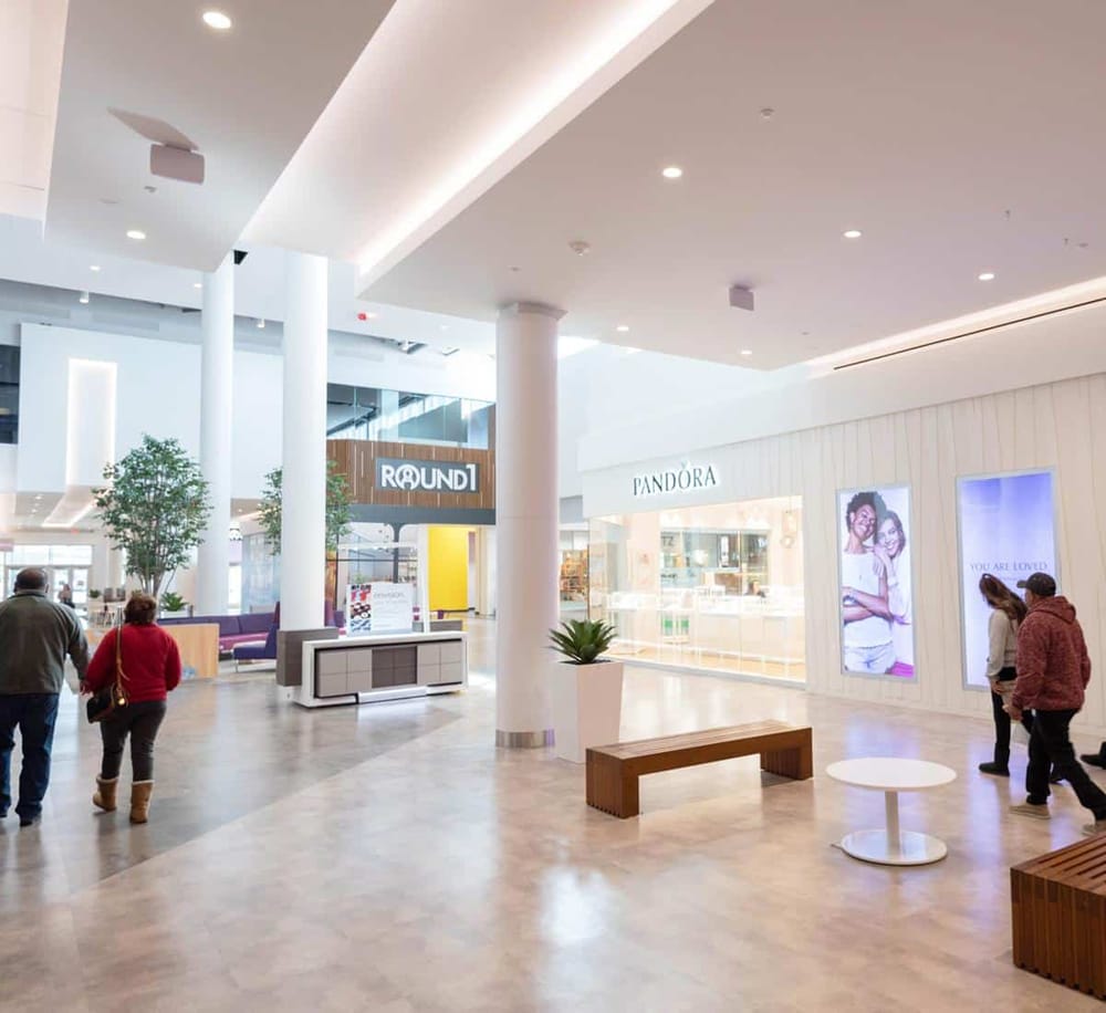 Bright modern mall interior with retail stores and seating areas, ideal for shopping and leisure.