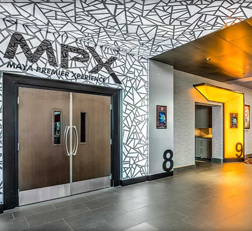 Modern hotel entrance with Maya Bremner Experience signage and artistic wall decor, ideal for travel and event venue SEO.