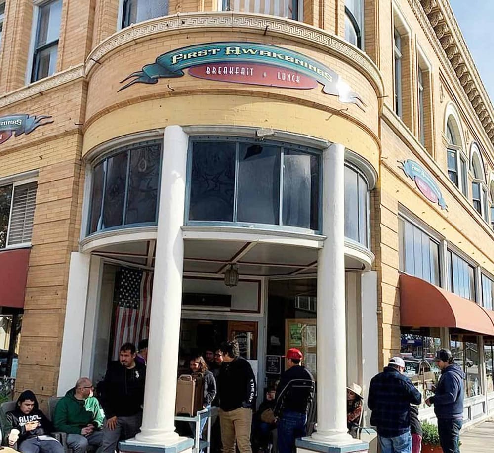 Cozy breakfast restaurant entrance with outdoor seating in a historic building, perfect for morning meals and brunch.