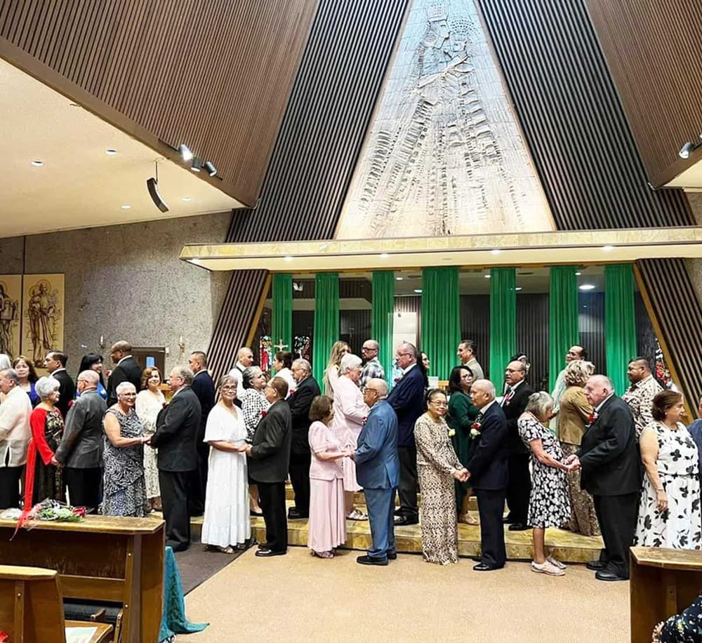 Older adults celebrating during a religious wedding ceremony in a church with green drapes and religious artwork.