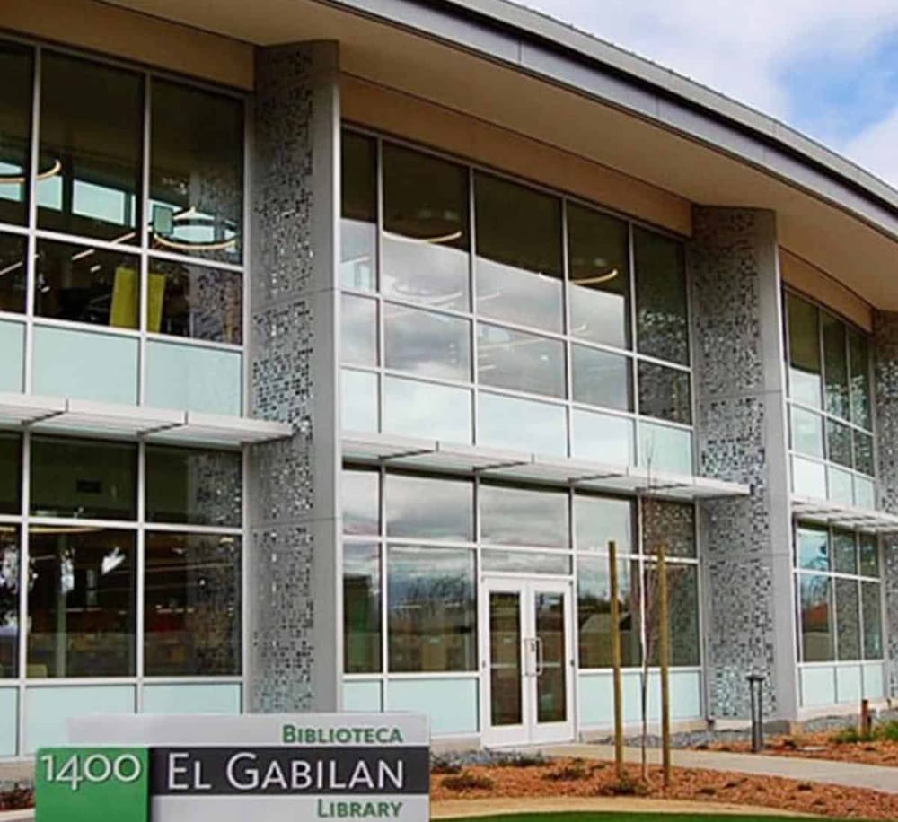 Modern public library building with large glass windows and contemporary architecture in a community setting.