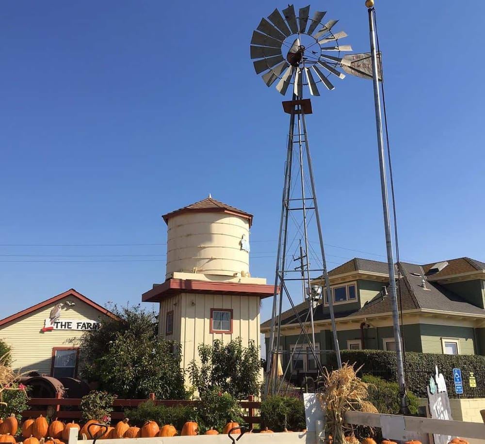 Rustic outdoor windmill and water tower with farm-style buildings, perfect for country-themed decor.