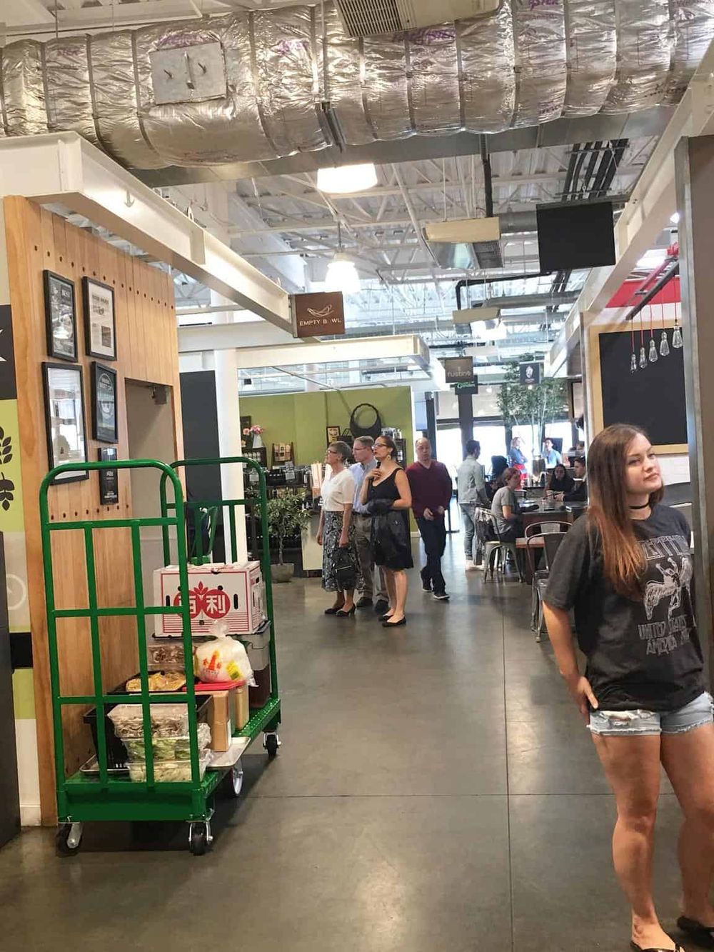 Bright indoor shopping mall with diverse customers, modern decor, and vibrant ambiance.