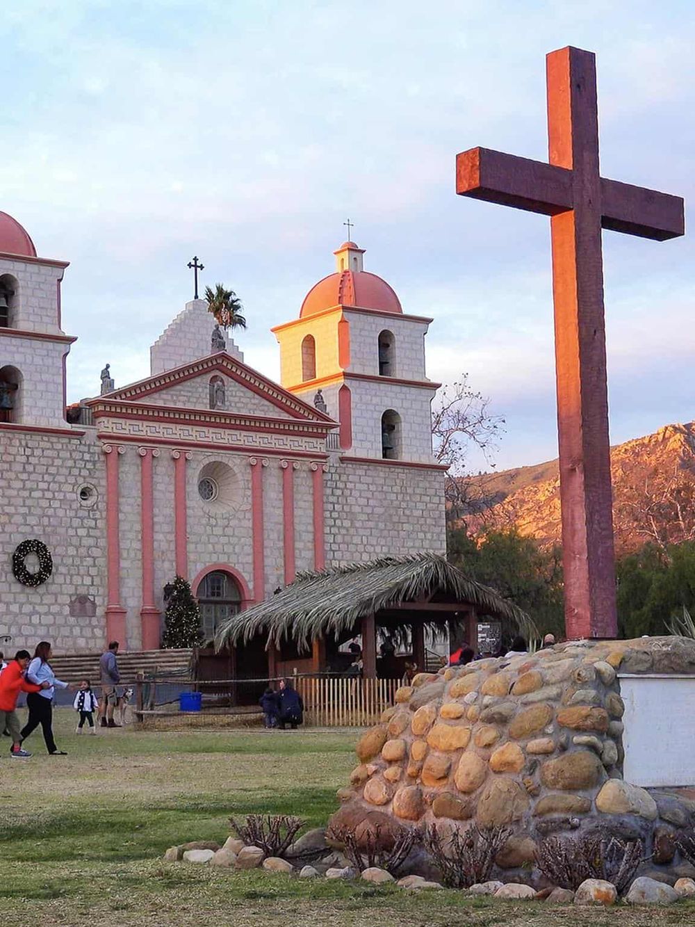 Colorful Mexican church with large cross, popular destination for sightseeing and cultural learning.