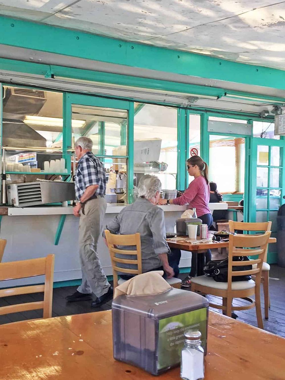 Comfortable casual restaurant scene with customers ordering food at the counter.