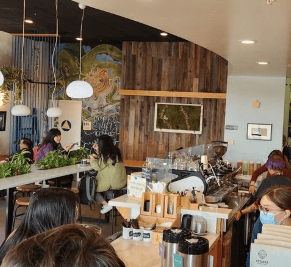 Cozy coffee shop interior with customers, modern decor, and a vibrant atmosphere.