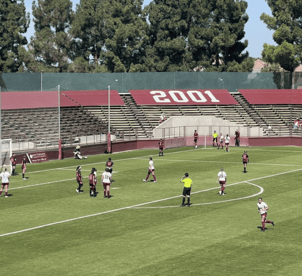Playing soccer match at QuestForDirections stadium with team and spectators.
