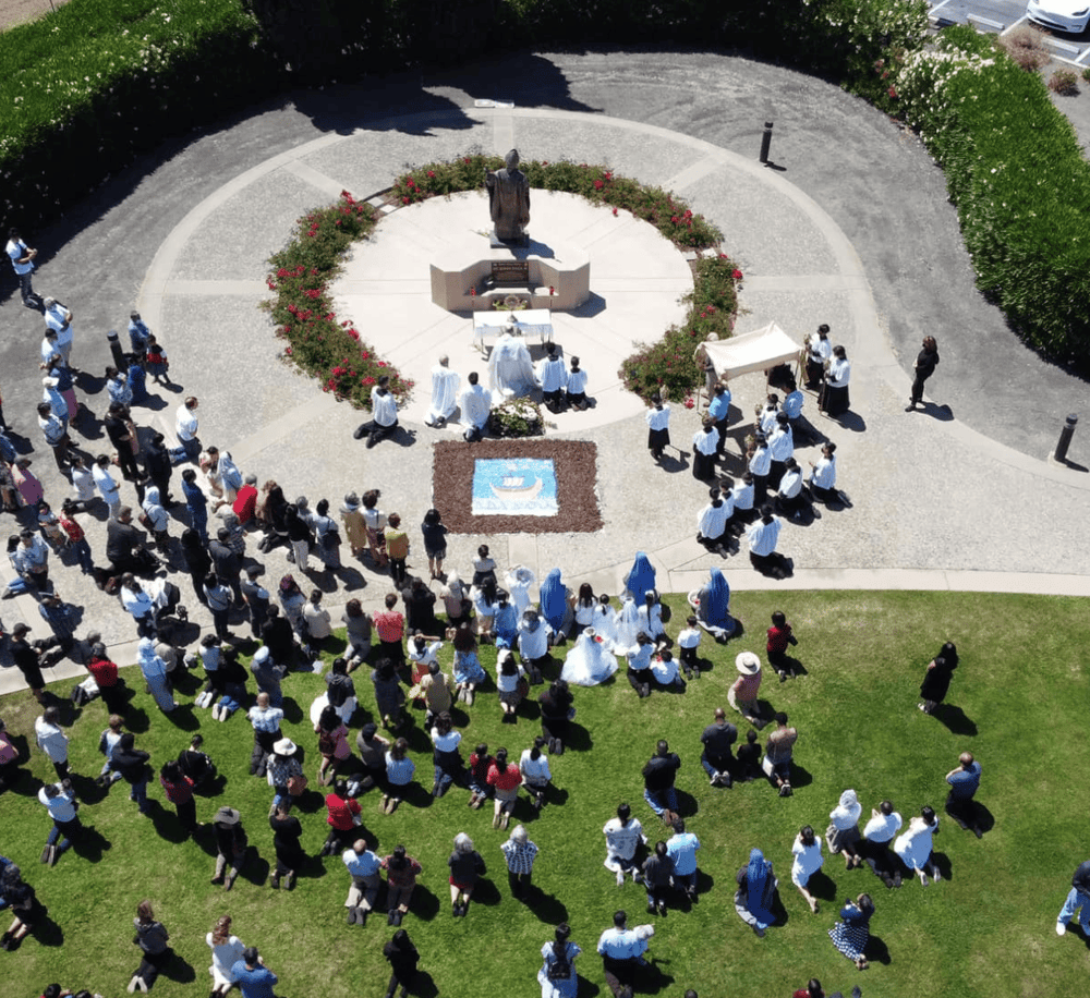 Prayer gathering at a monument, outdoor religious event, community prayer, spiritual ceremony, church event, faith gathering.