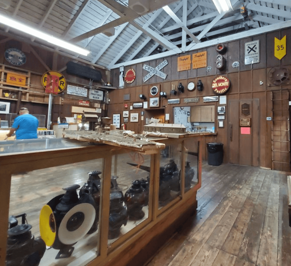 Industrial model train display inside a vintage railway station or museum.