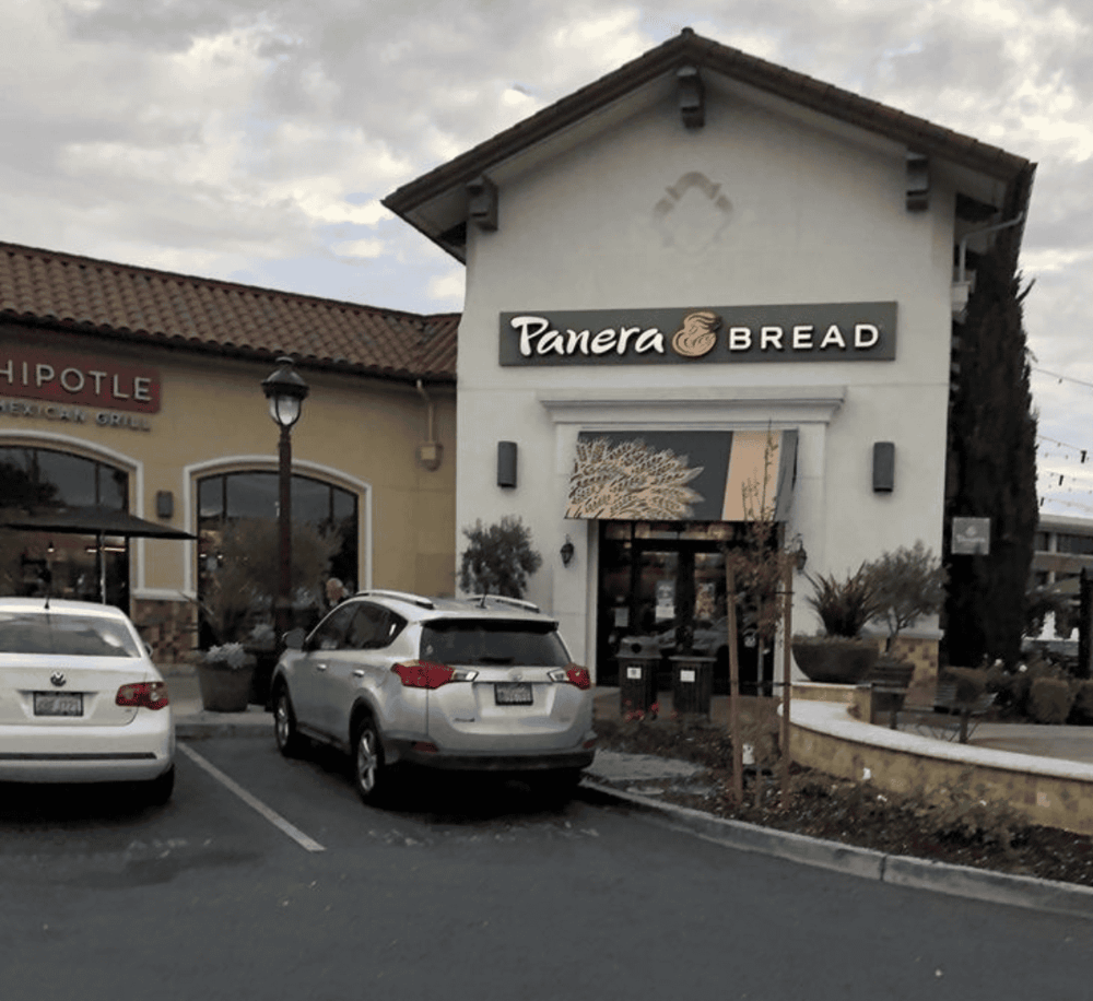 Panera Bread restaurant exterior in shopping center, parking lot, and adjacent retail stores SEO keywords.