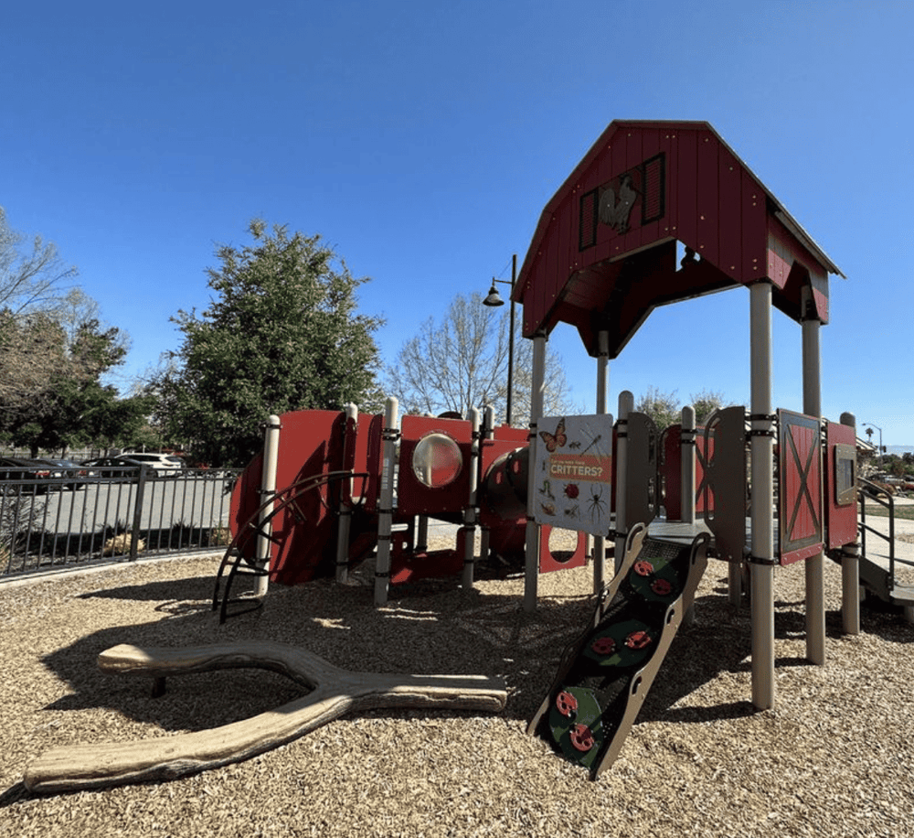 Colorful children's playground with animal-themed equipment and slide at outdoor park.