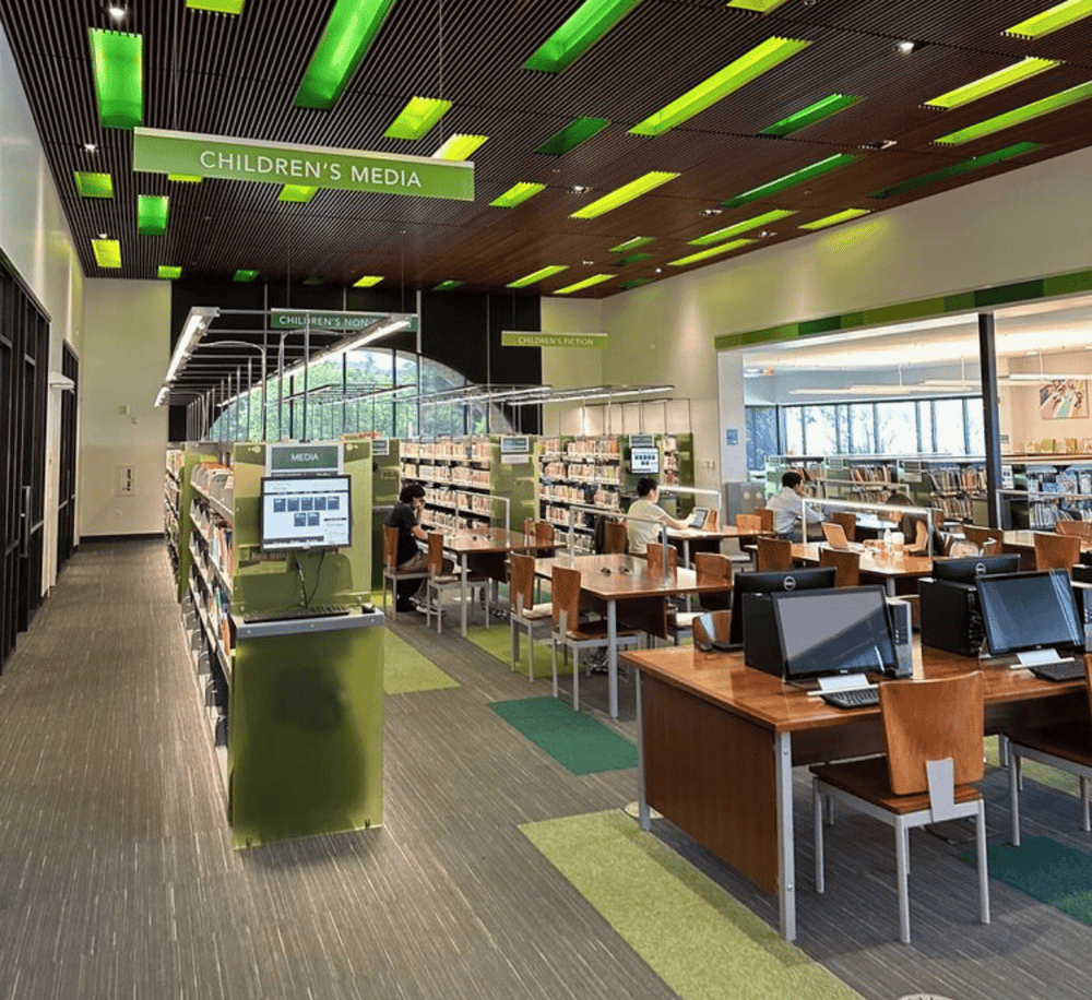 Bright modern library interior with digital catalogs and study areas for children and adults at QuestForDirections.
