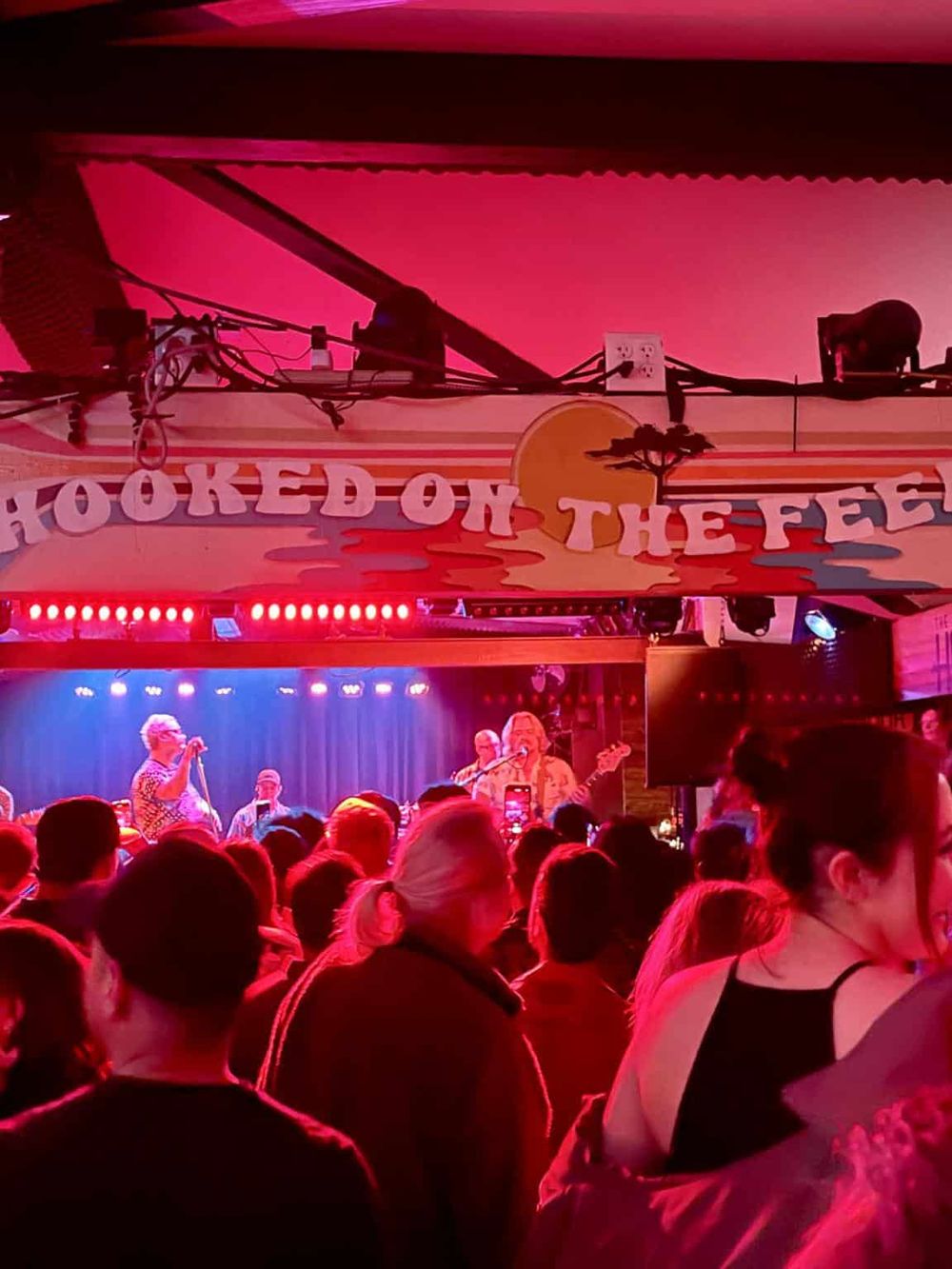 Vibrant live music performance at Hooked on the Feed bar, with an energetic crowd enjoying the show in a lively atmosphere.