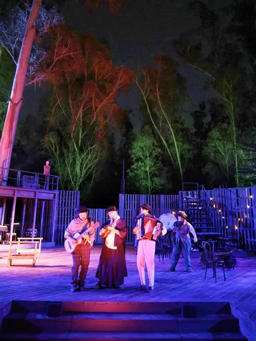 Vibrant nighttime outdoor performance with musicians on stage and colorful lighting, highlighting QuestForDirections' entertainment event.