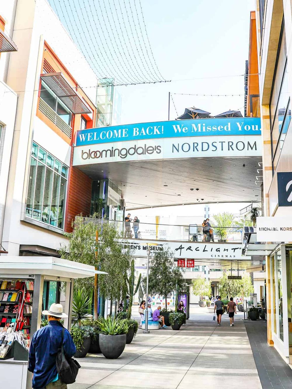 Vibrant shopping mall with Bloomingdale's and Nordstrom, featuring welcoming signage and outdoor seating.