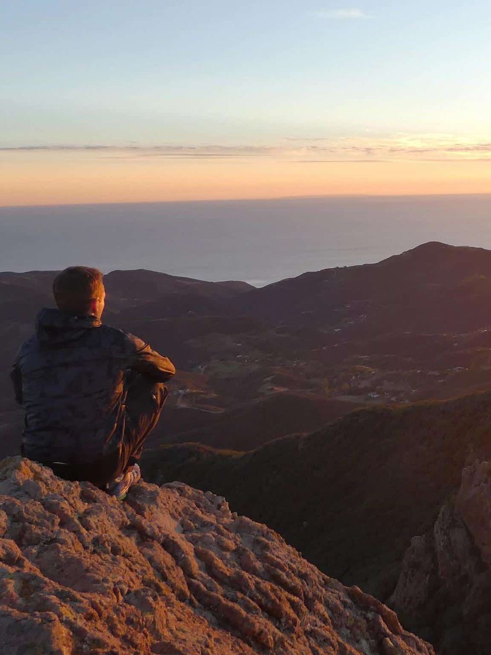 Enjoying breathtaking sunset views from a mountain summit, ideal for adventure and nature enthusiasts seeking reliable directions.