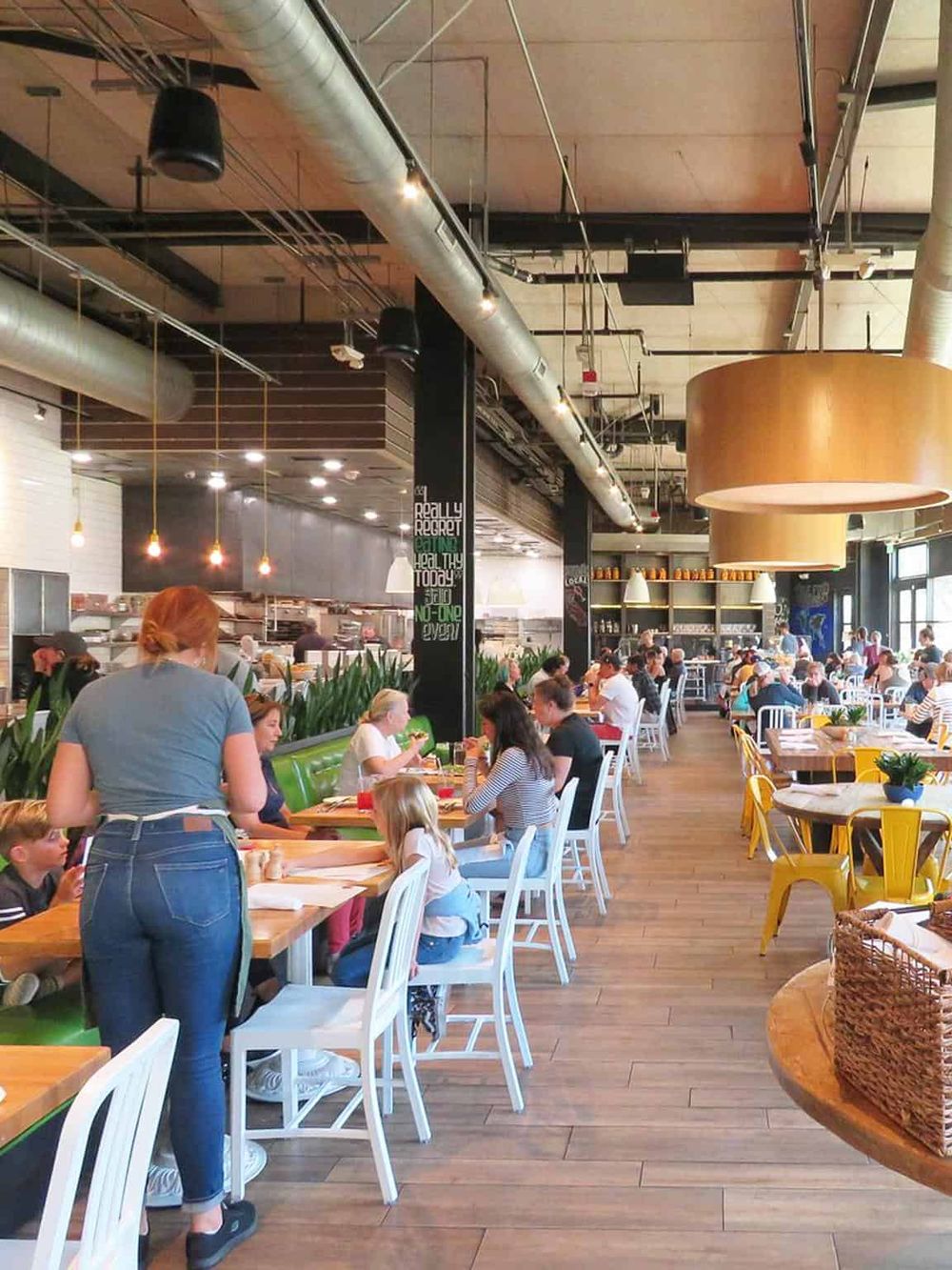 Brightly lit modern restaurant interior with diverse guests dining and socializing.