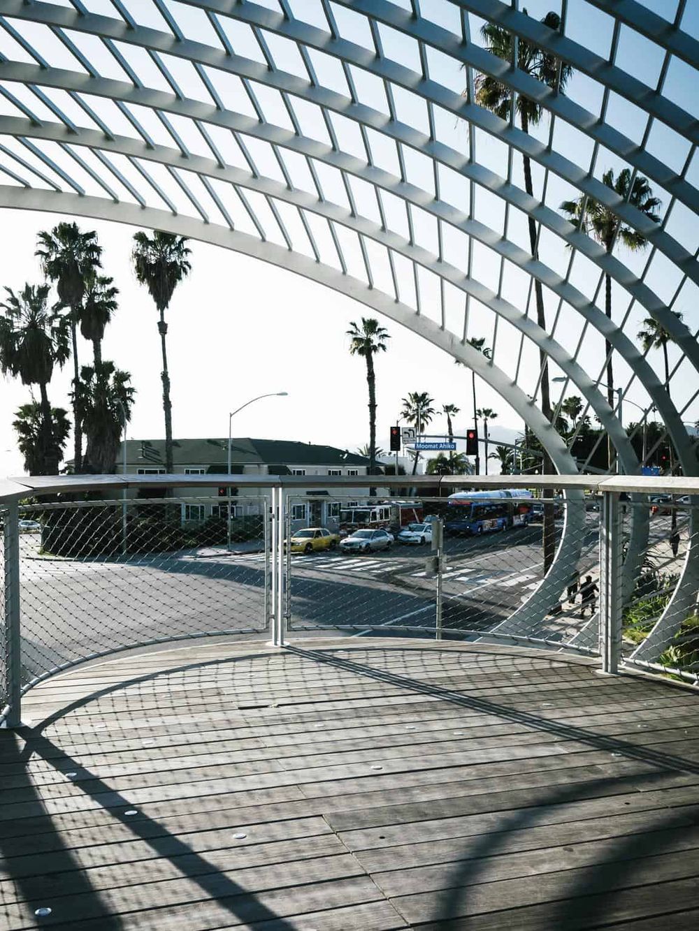 Modern bridge structure with city street view and palm trees in Los Angeles, California.