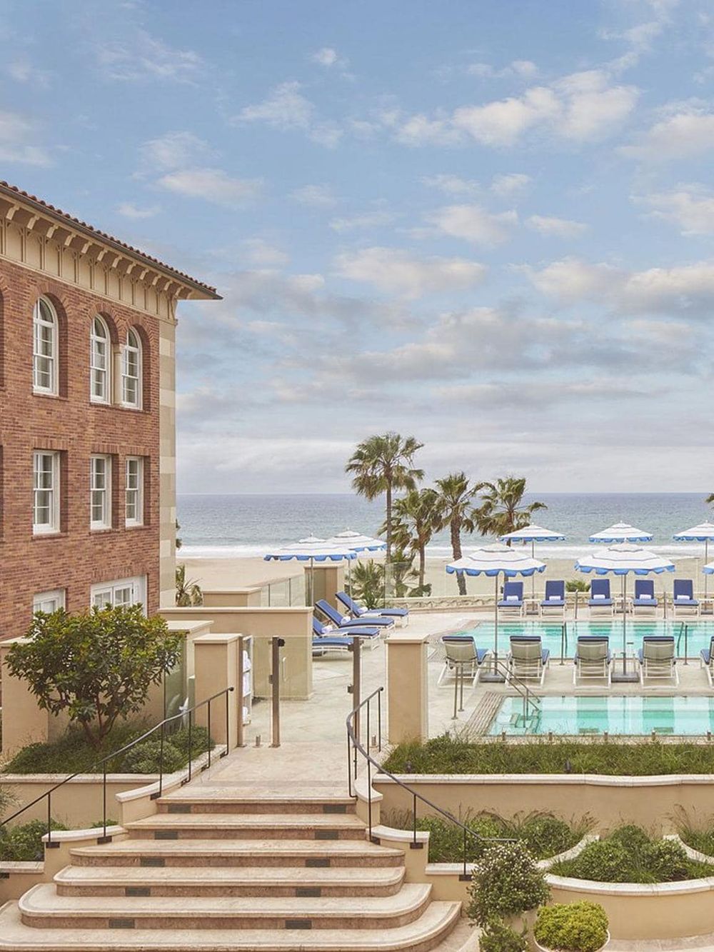Beachfront hotel pool area with ocean view, palm trees, and summer outdoor decor.