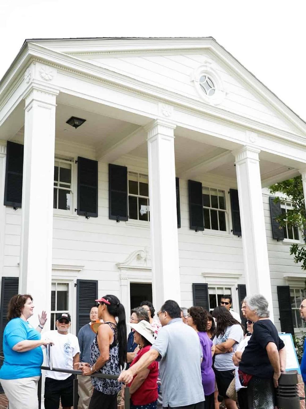 Historic house tour with guided group outside, vibrant community experience, detailed architecture, and engaging storytelling.
