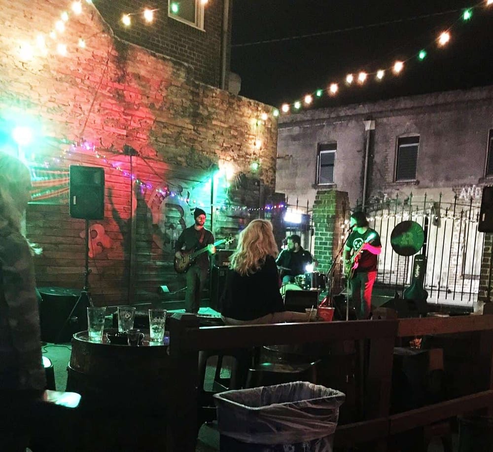 Live outdoor band performance at QuestForDirections event venue, vibrant night scene, local music, lively atmosphere.