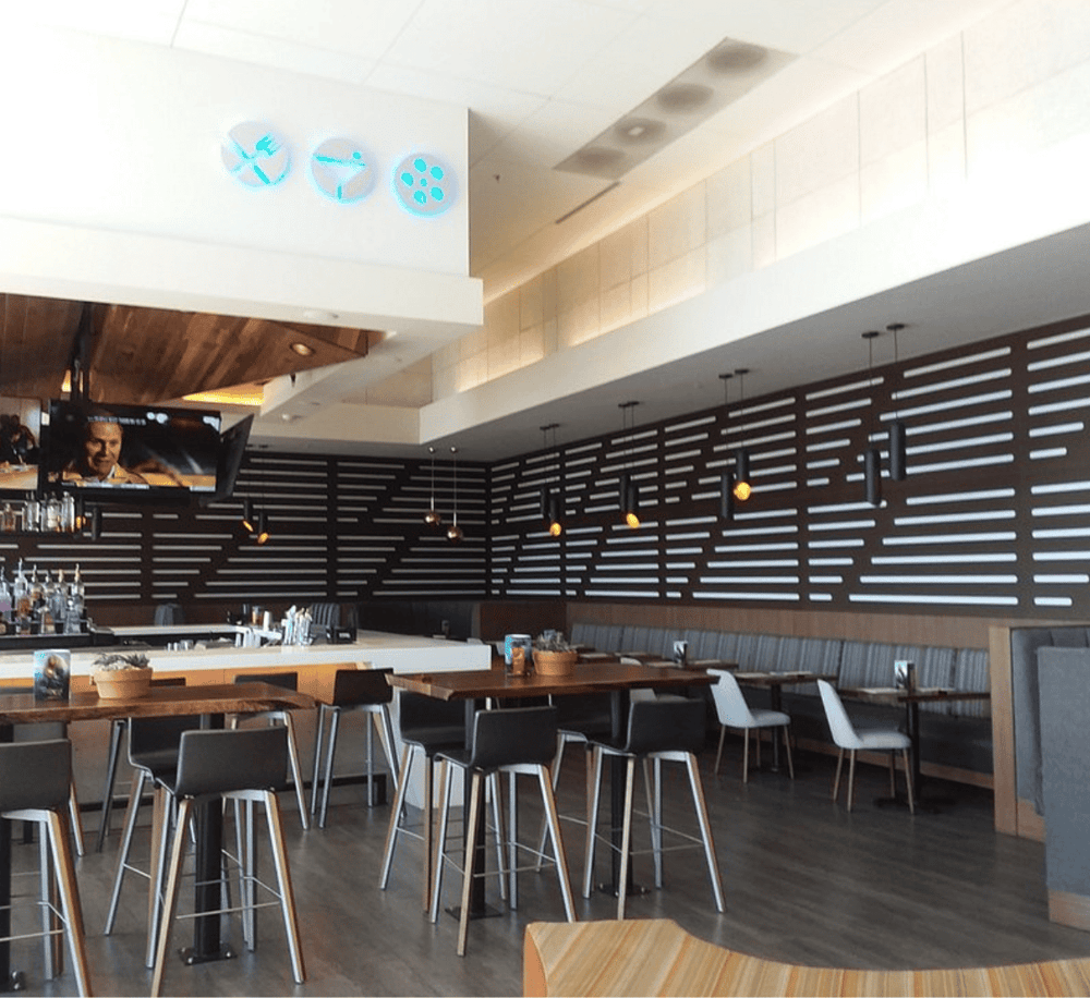 Modern restaurant interior with stylish wood accents and ambient lighting, ideal for dining and social gatherings.