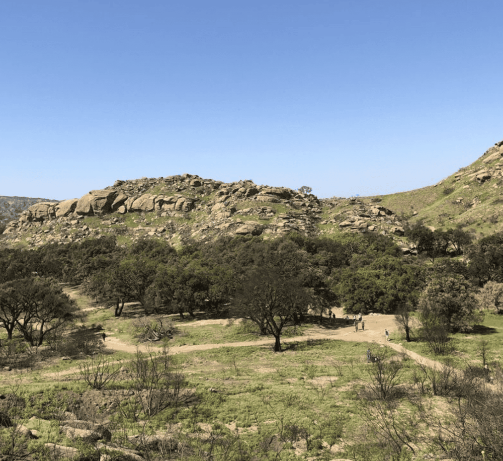 Rugged mountain landscape with rocky hills and green shrubbery, ideal for outdoor adventures and nature exploration.