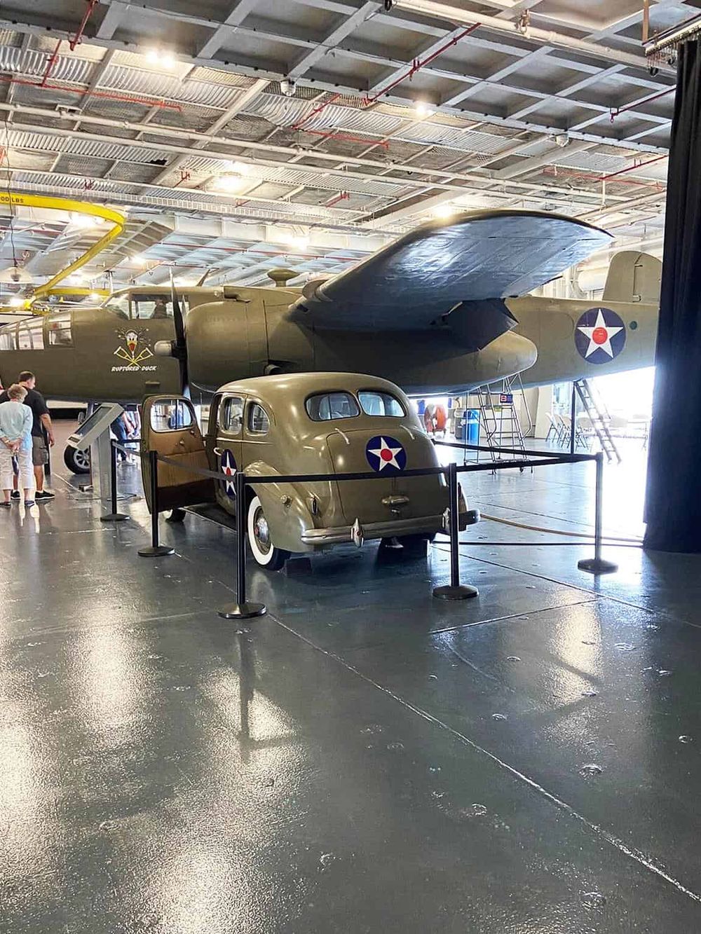 Vintage military aircraft and vehicle exhibit at an aviation museum.