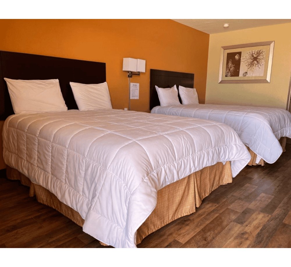 Comfortable hotel room with two queen beds and cozy decor, perfect for restful stays.