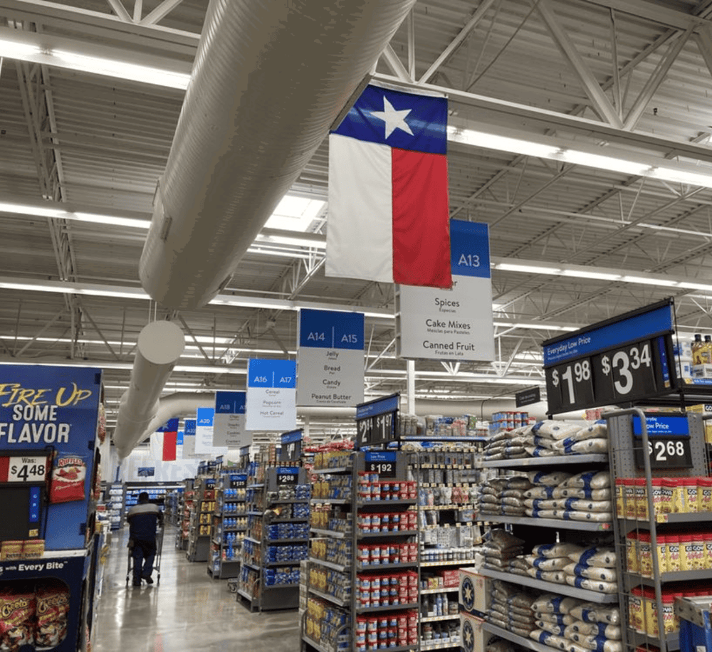 Flag of Texas in a retail store aisle, guiding customers to spices, cake mixes, and canned fruit.