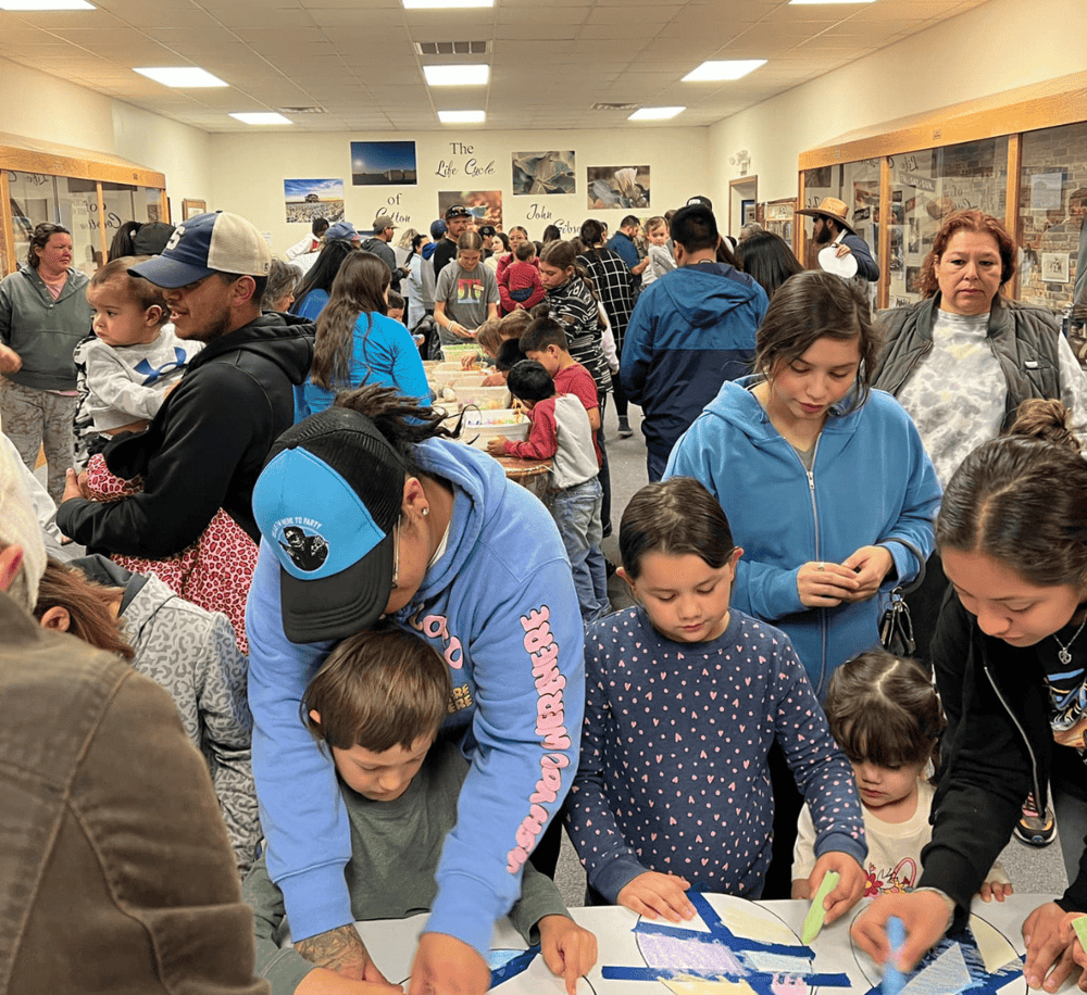 Kids and families engaging in interactive activities at QuestForDirections community event in a museum setting.