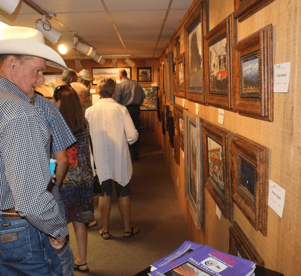 Enthusiastic visitors explore artwork at Quest for Directions art exhibit showcasing local and regional paintings.