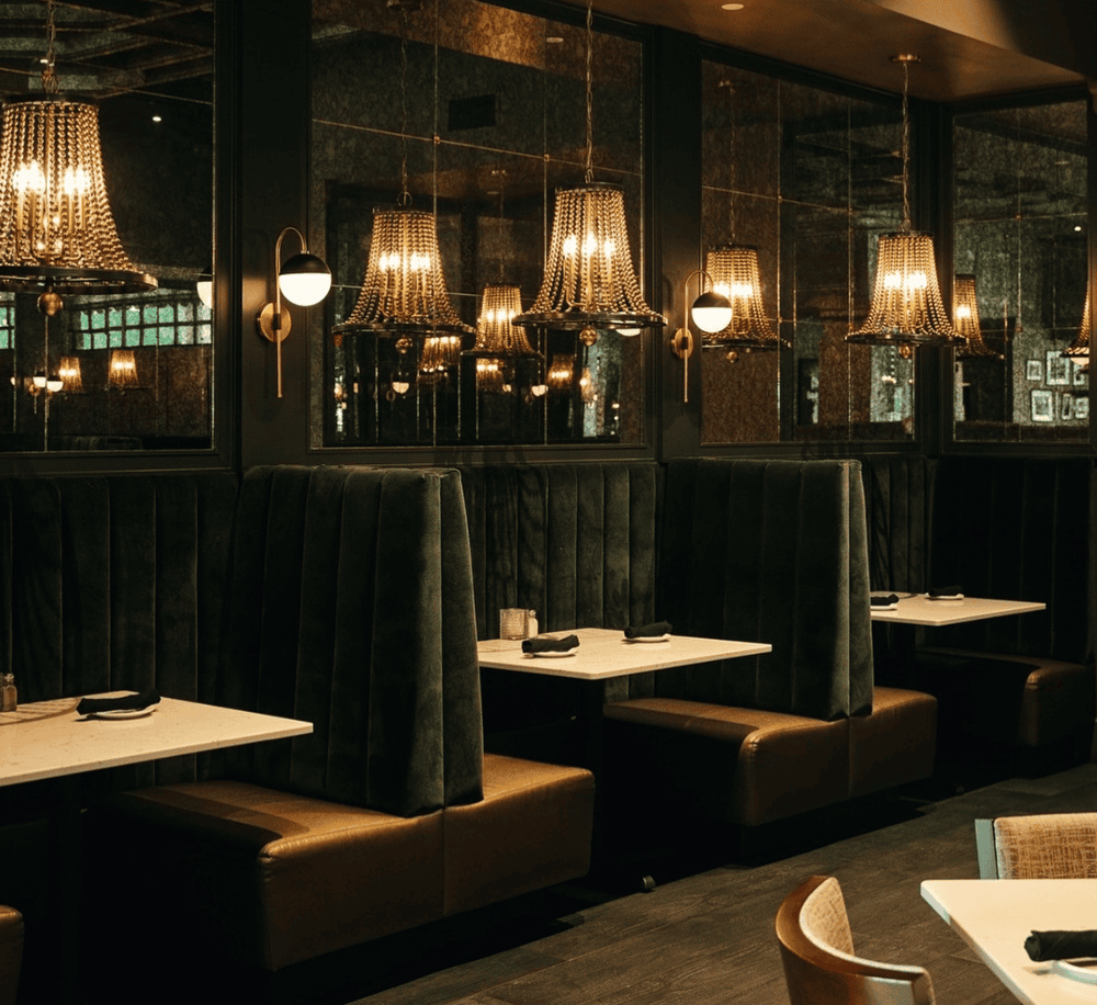 Elegant restaurant interior with ambient lighting and plush booths, perfect for fine dining and events.