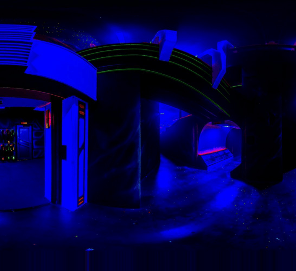 Vivid neon-lit corridor inside an entertainment or gaming facility with futuristic design elements.