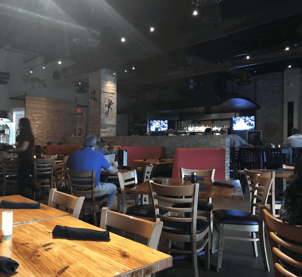 Cozy restaurant interior with modern decor, dining tables, and a bar area, perfect for casual dining and social gatherings.