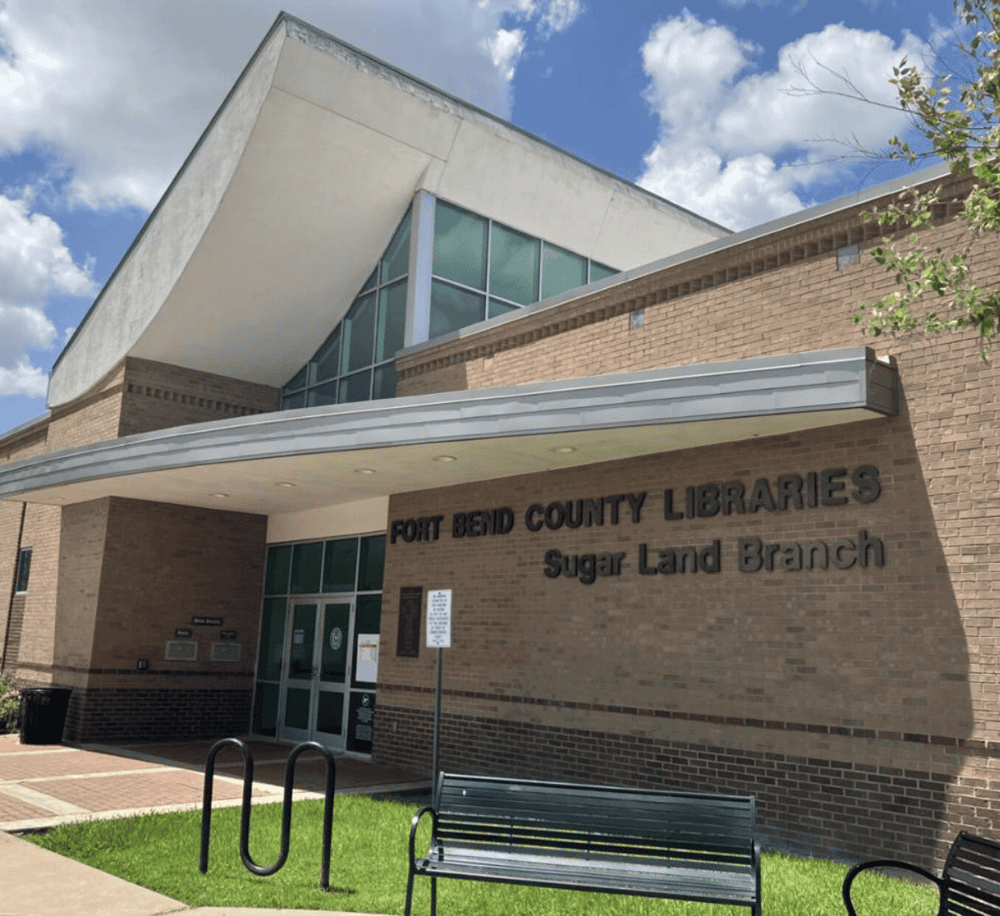 Fort Bend County Libraries Sugar Land Branch, modern library building with brick facade, inviting outdoor seating area.