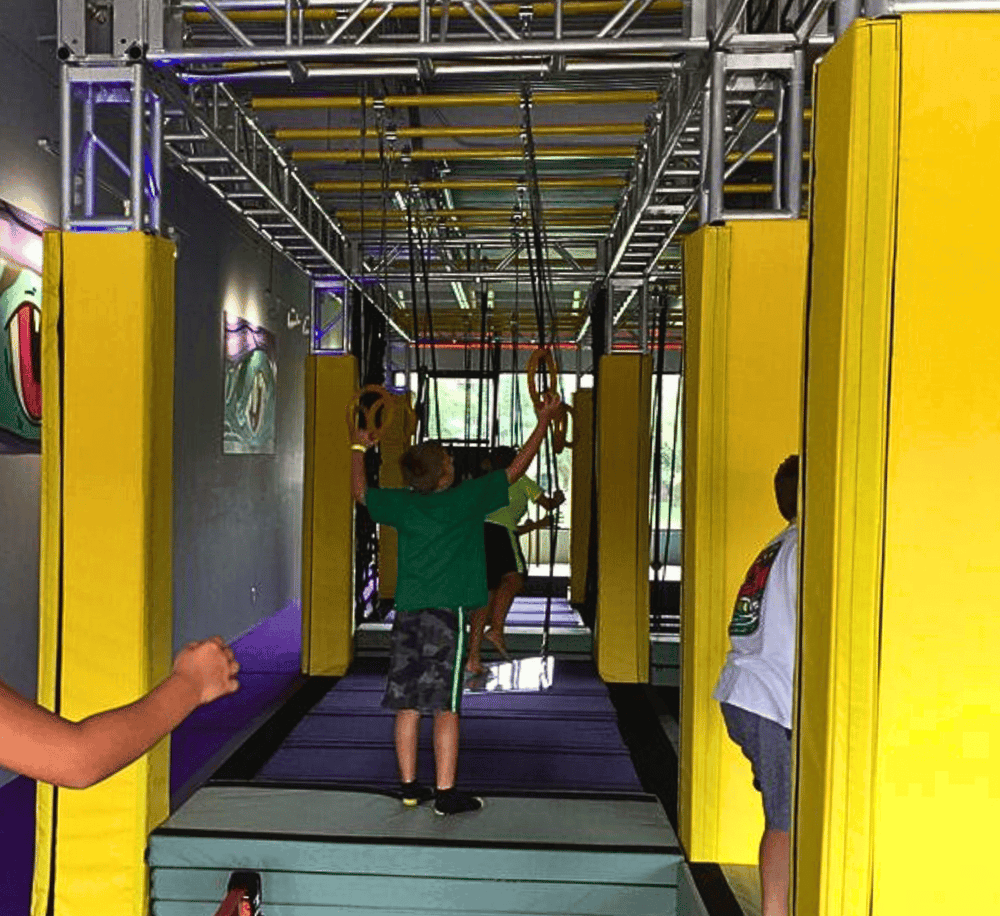 Kids playing on indoor ninja obstacle course for children’s entertainment and adventure.