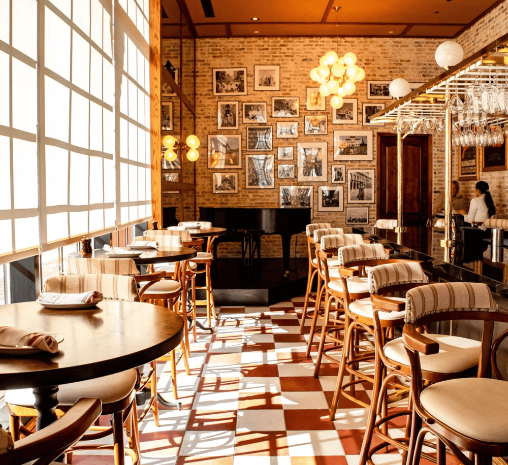 Cozy restaurant interior with vintage decor, bar seating, and framed photos, perfect for dining and socializing.