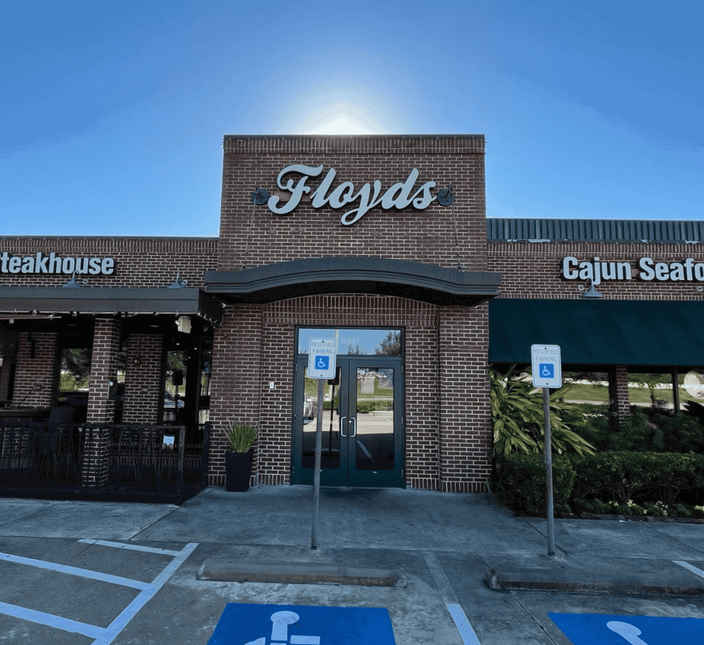 Comfortable brick storefront of Floyd's restaurant with accessible parking spaces outside.