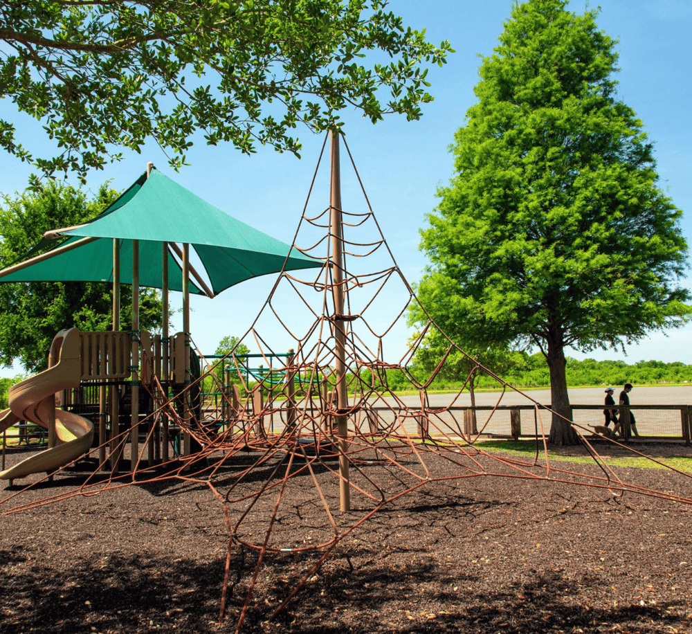 Colorful outdoor playground with climbing equipment and shade canopy for kids.