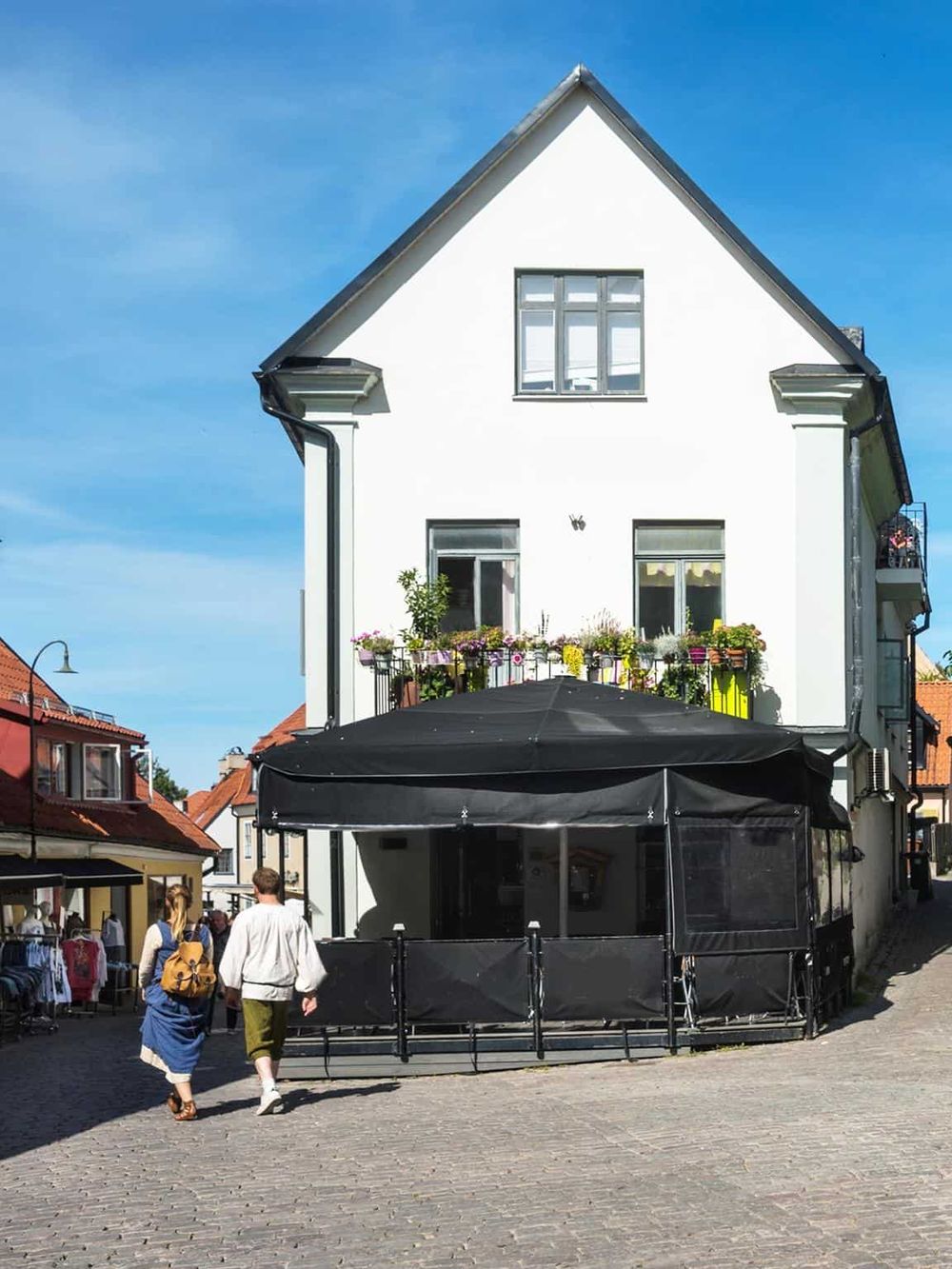Charming white building with outdoor seating, in a historic town center, perfect for dining and exploring local attractions.