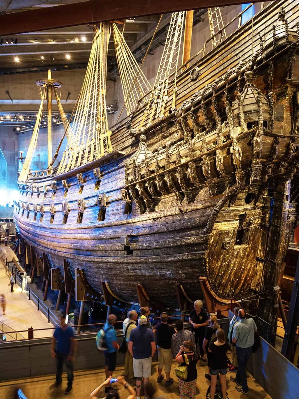 Ancient wooden ship exhibit at museum, with visitors exploring maritime history and ship architecture.
